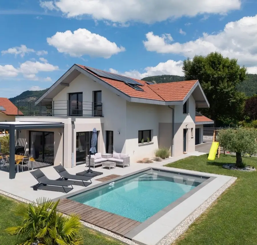 Maison familiale avec toit deux pans, piscine, pergola bioclimatique et panneaux solaires.