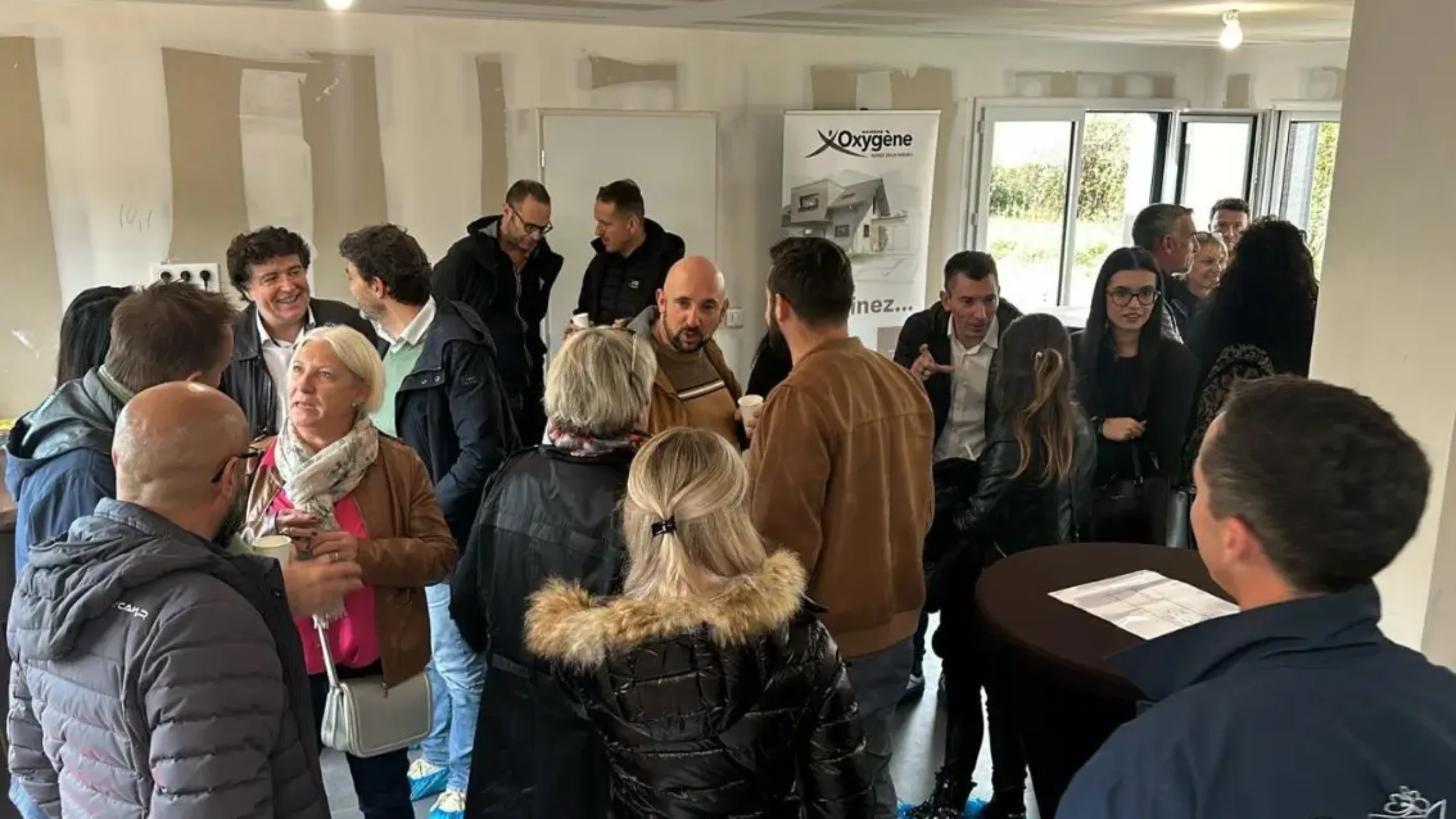 Groupe de visiteurs échangeant dans une maison en chantier