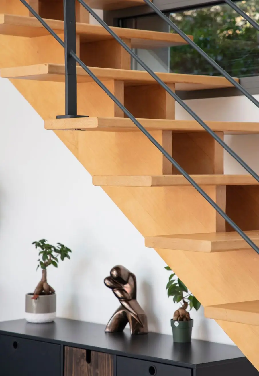 Escalier moderne en bois clair avec garde-corps métallique dans un intérieur contemporain