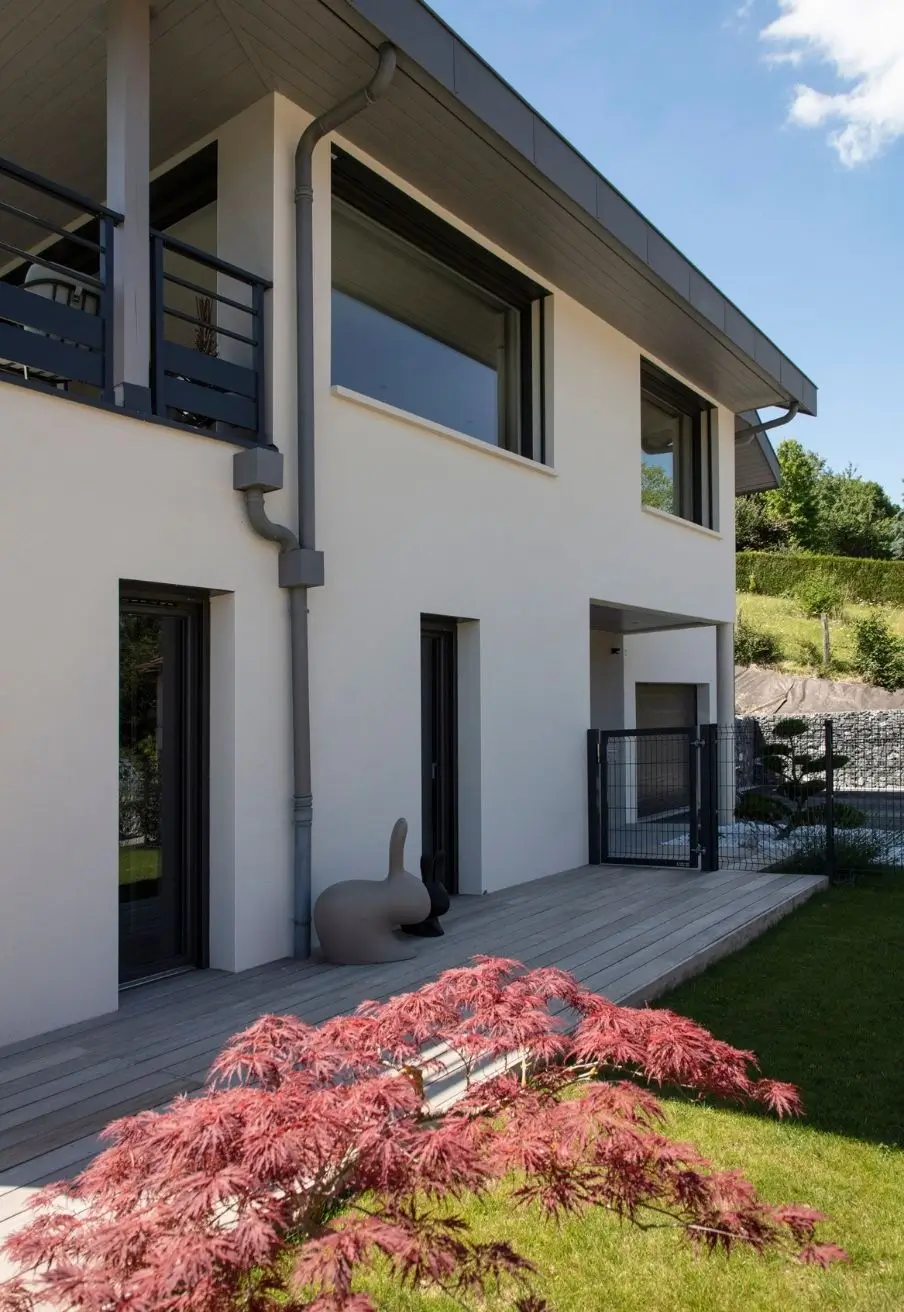 Façade de maison moderne à Sevrier avec terrasse en bois et jardin paysager