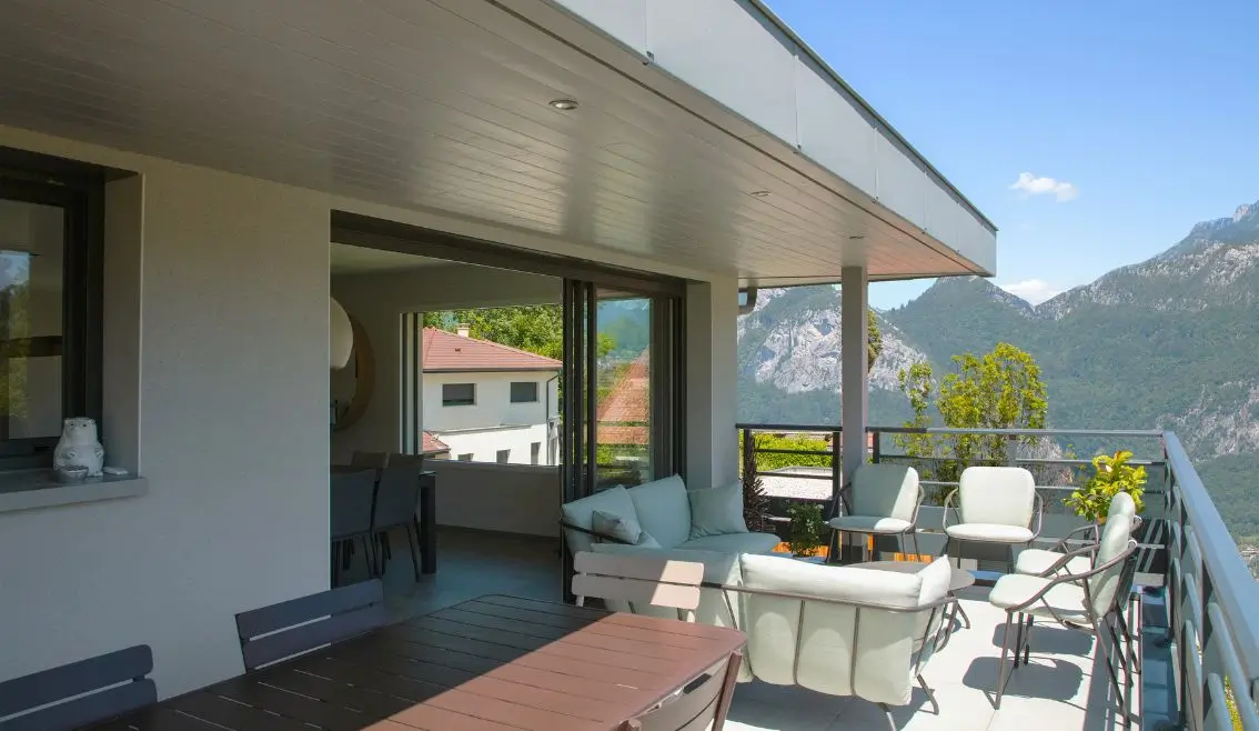 Terrasse couverte d'une maison contemporaine avec vue panoramique sur les Alpes