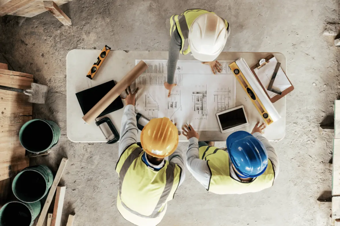 artisans partenaires et conducteur de travaux qui travaillent sur le plan d'une maison