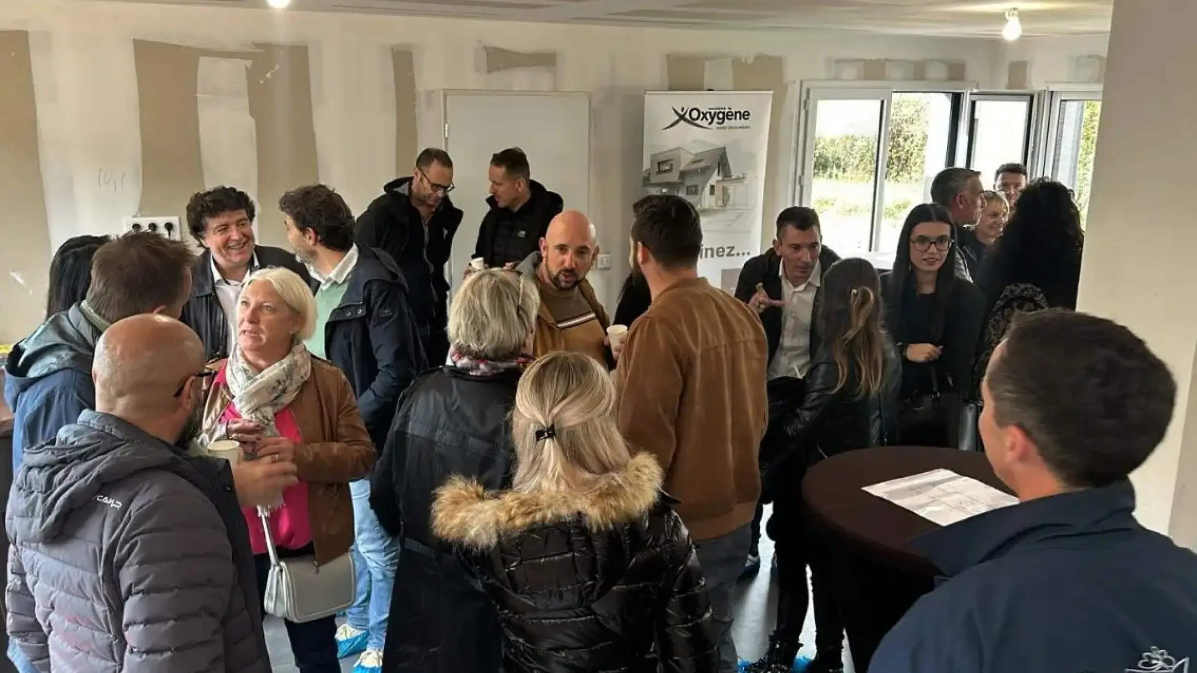 Groupe de visiteurs échangeant dans une maison en chantier
